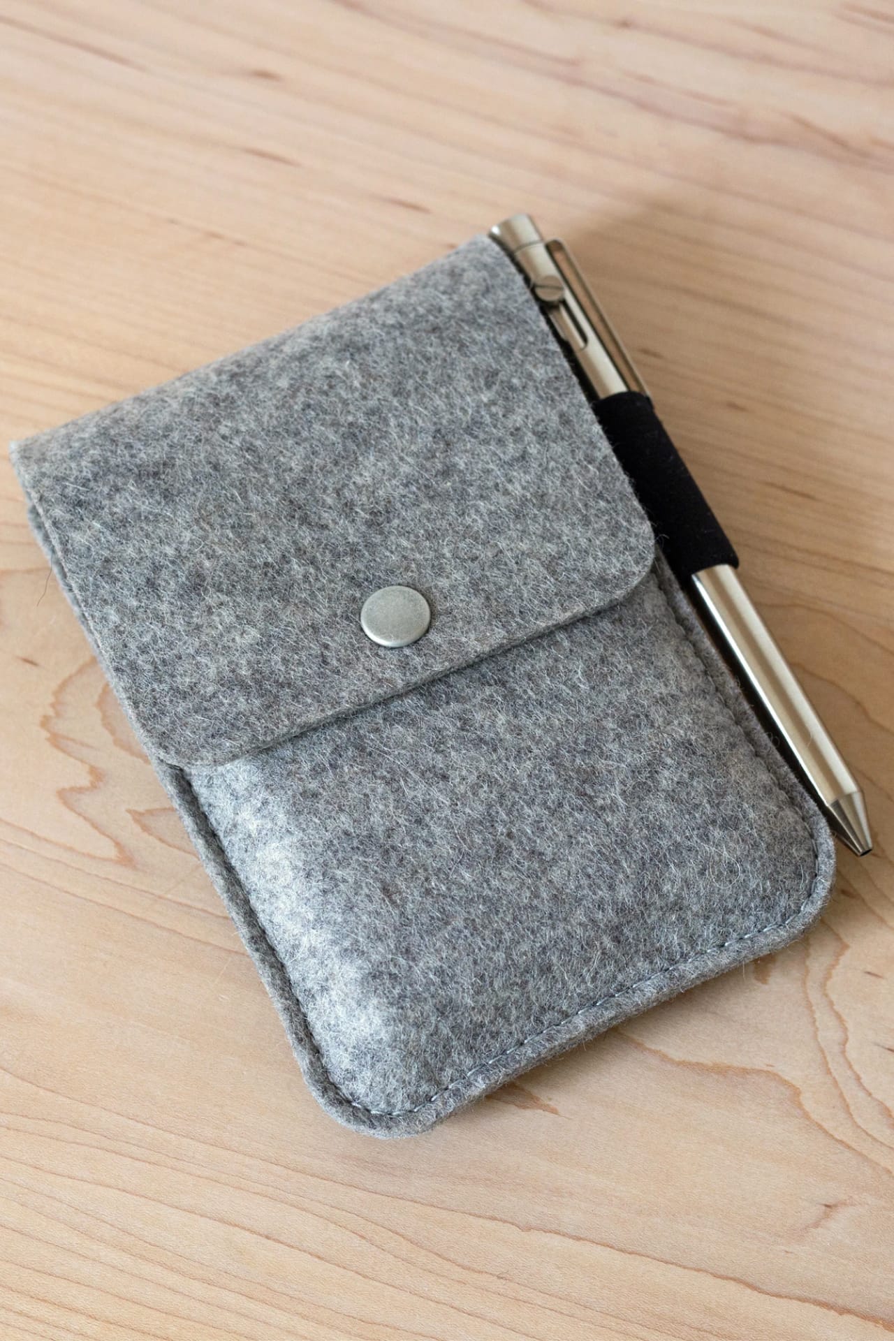 Textured gray felt pouch for paper cards with snap button flap and elastic pen holder loop.