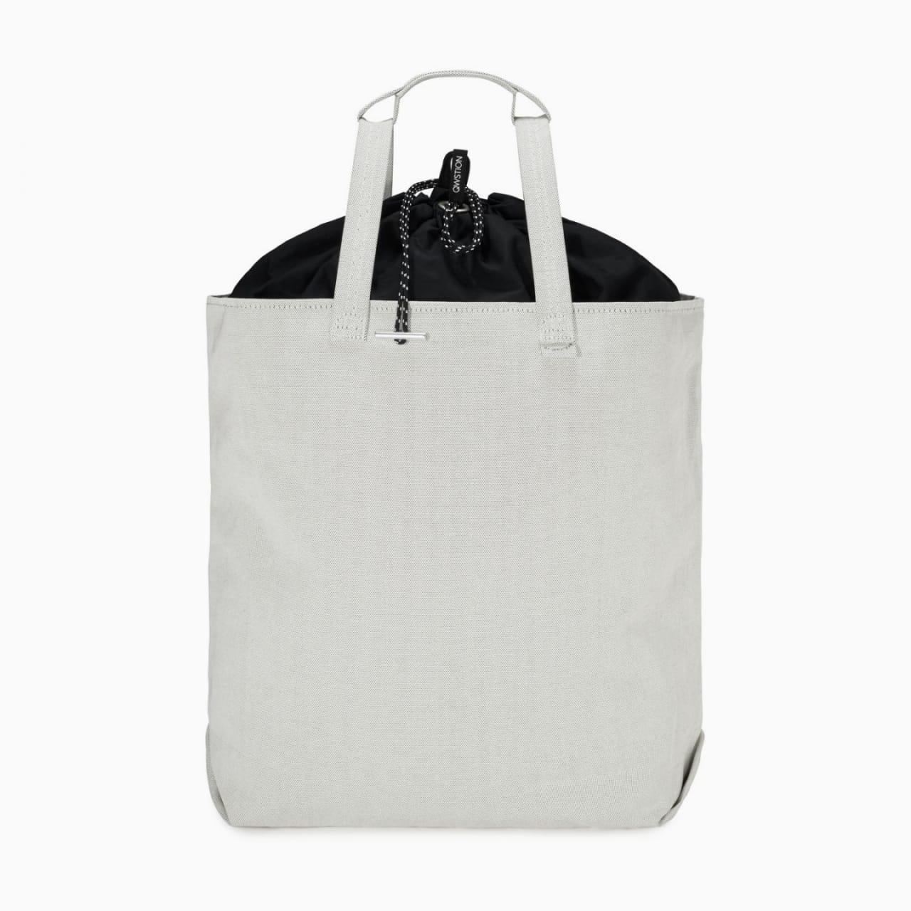 Front of zip tote bag with white canvas, white handles, and black drawstring top.