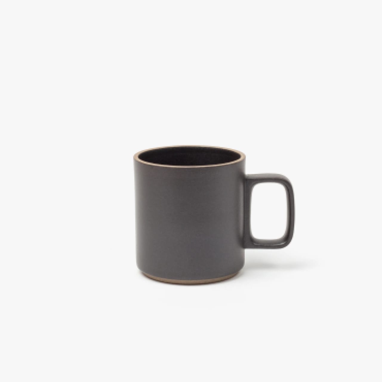 Black porcelain mug with modern square handle and natural clay accents on rim and bottom.