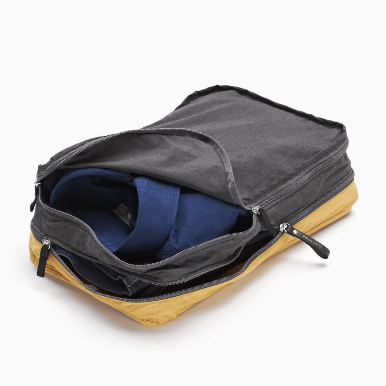 Garment bag with two layers of grey and tan zipper pouches for folded shirts and pants.