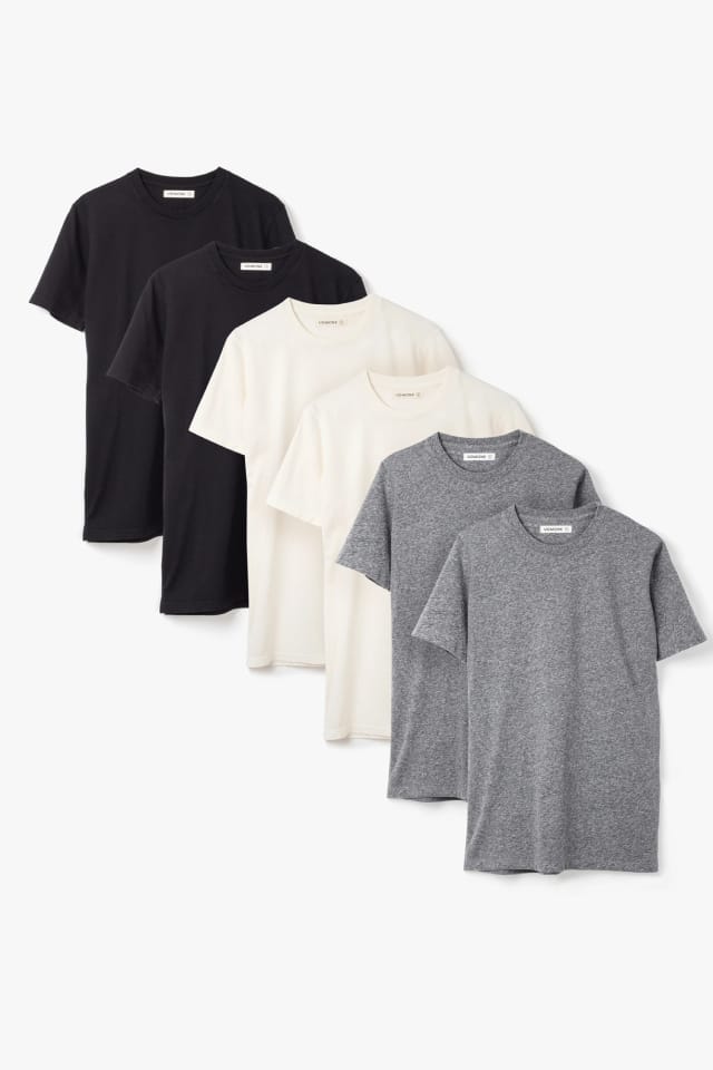 Two each of gray, white, and black shirts arranged on table.