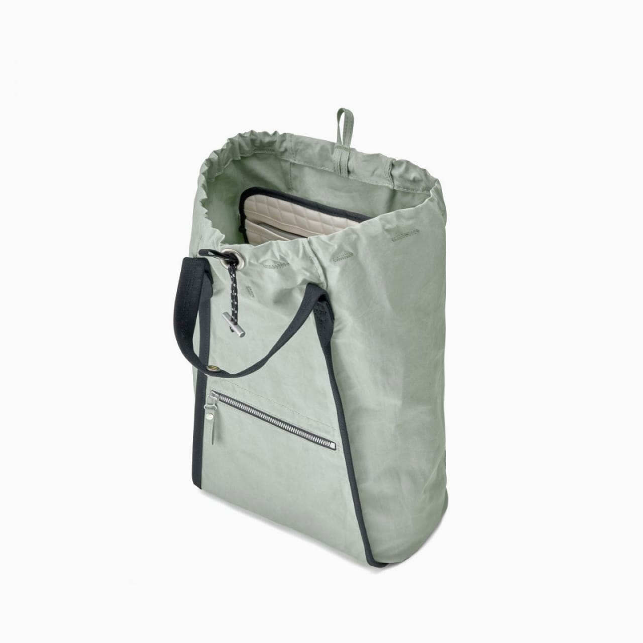 Interior of light green canvas bag with padded laptop sleeve and internal organization pouch.