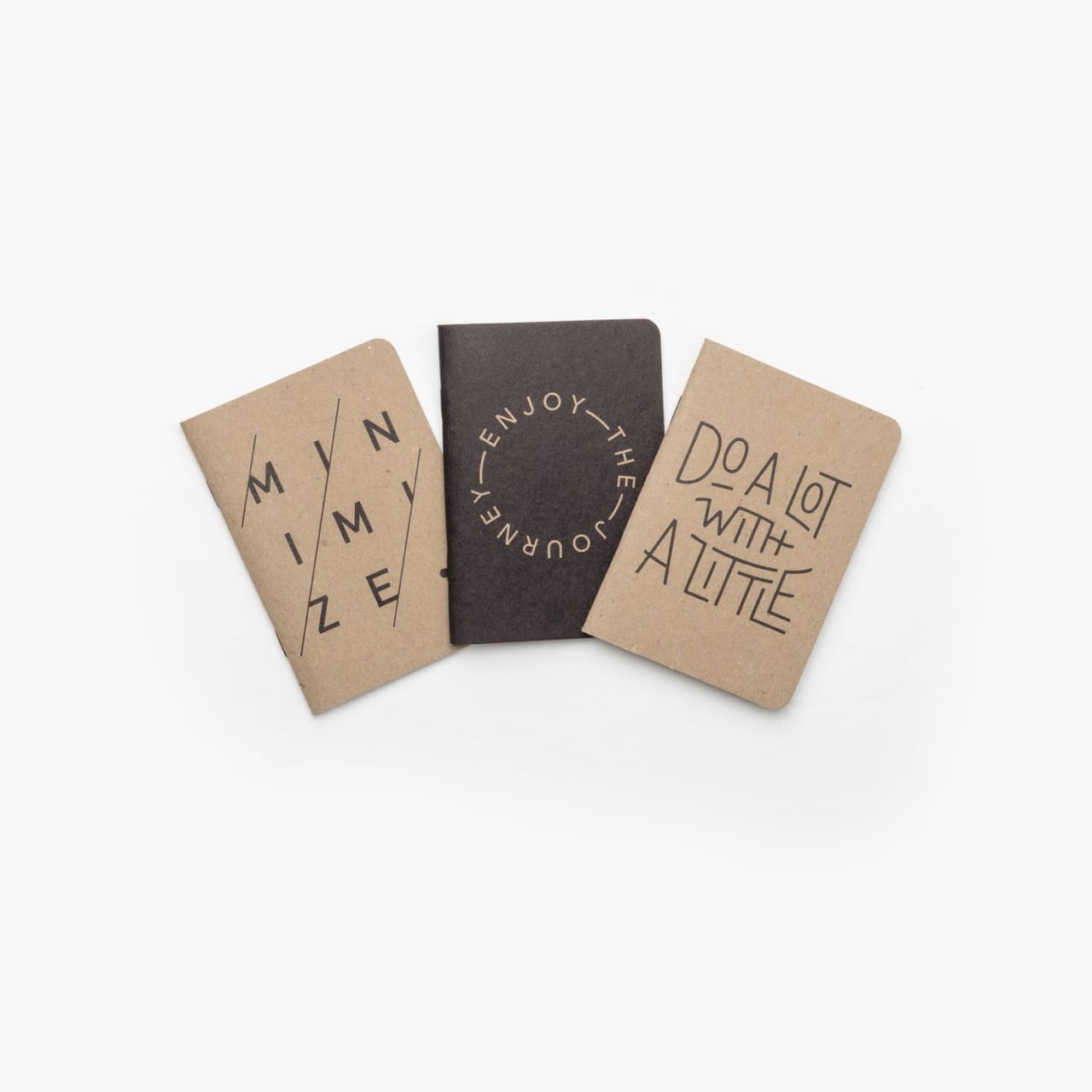 Three mini sketchbooks with tan and charcoal typography poster covers.