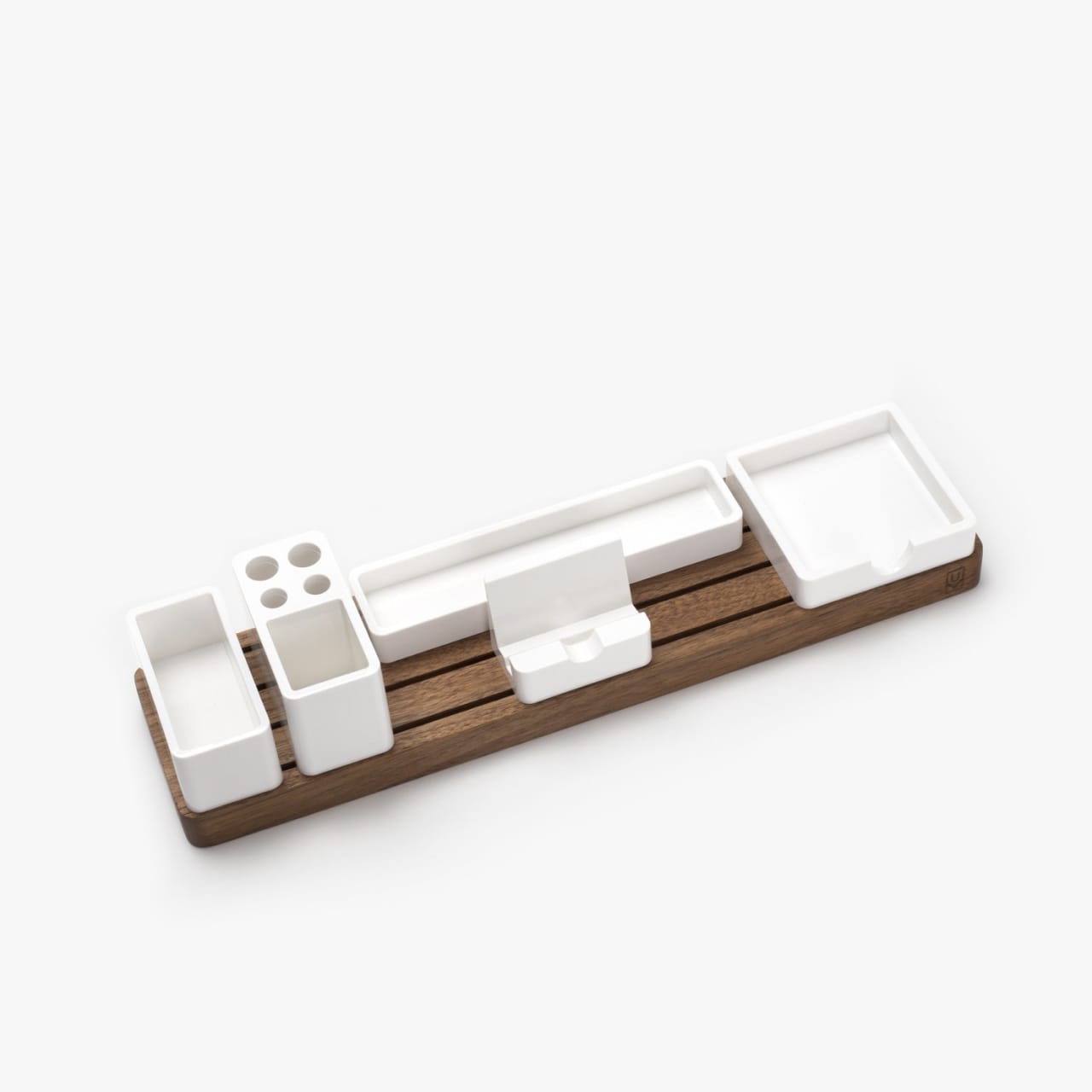 Grooved walnut desk organizer base with five modular white plastic organizer trays.